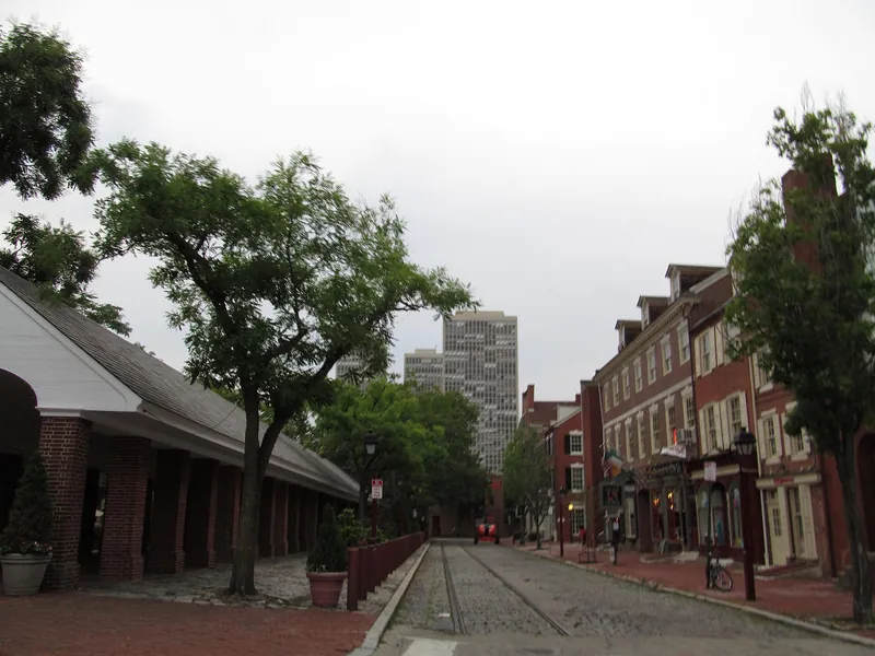 Brick market shed and rowhouses along cobbled 2nd Street